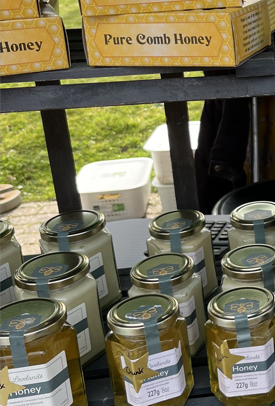 Boxes of pure comb honey and jars of honey on the Lovelands Honey market stall