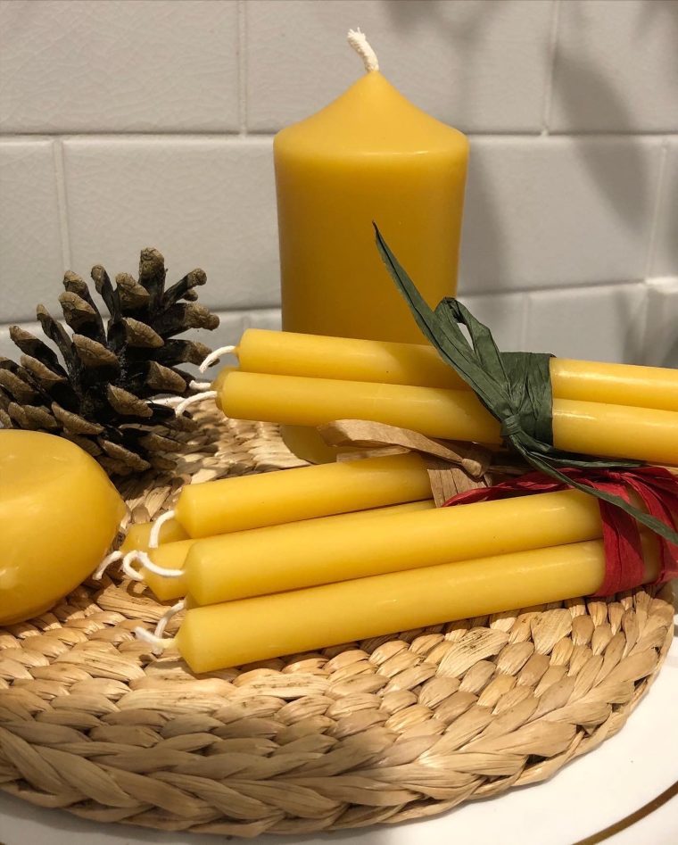 Beeswax candles made at Lovelands, tapers and a pillar candle on a woven mat