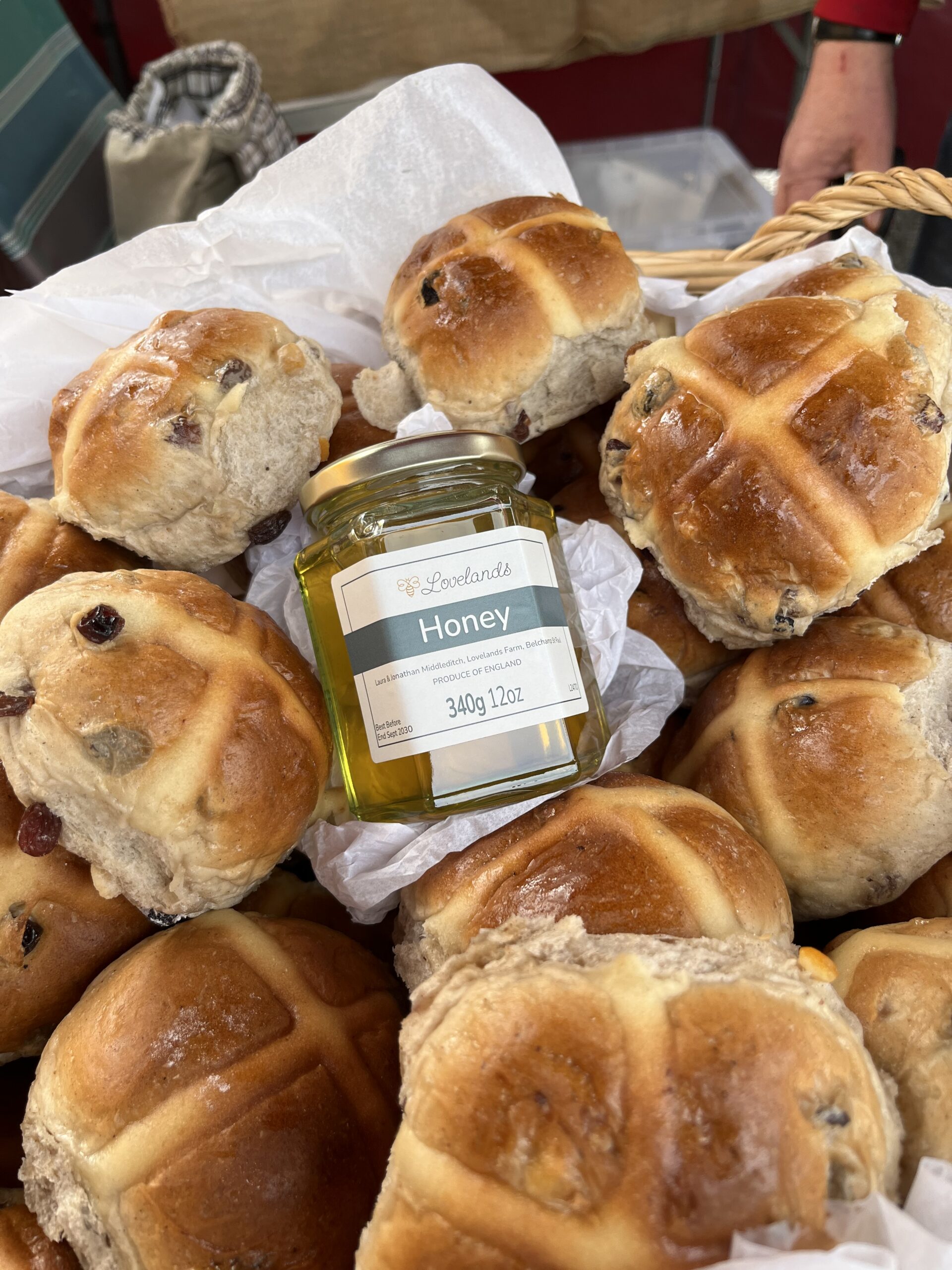 Hot cross buns beside a jar of Lovelands honey